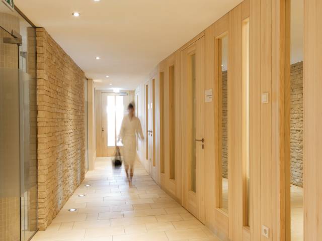 Frau im Bademantel läuft durch den Wellnessbereich