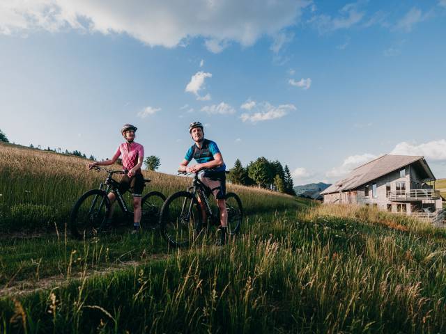 Pärchen auf dem Fahrrad vor dem Hotel