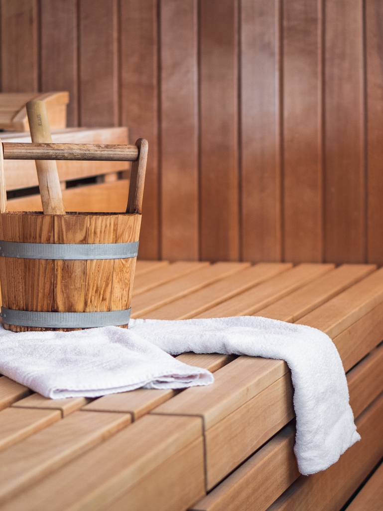 Handtuch und Wassereimer auf den Sauna-Sitzbänken