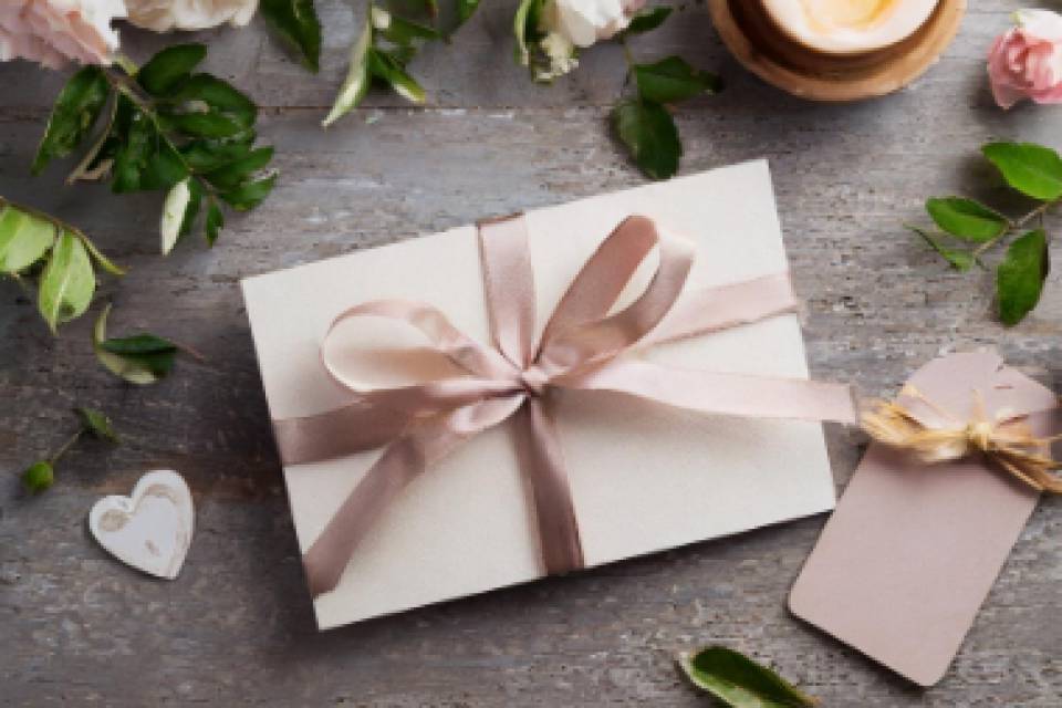 Verpackter Umschlag auf Tisch mit Kerze und Rosen