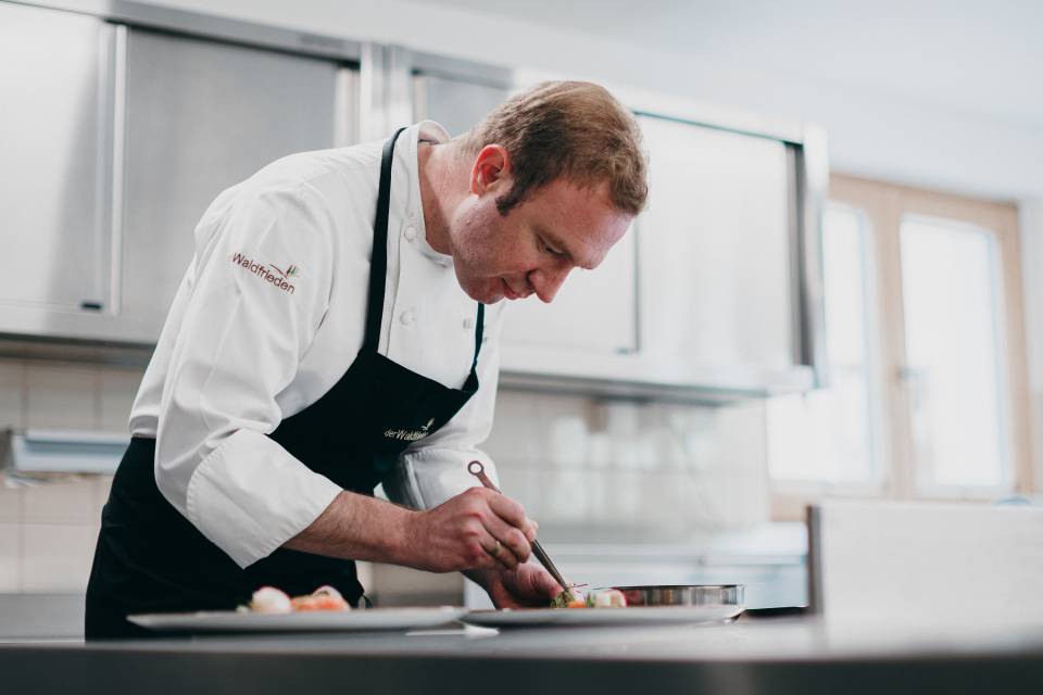 Küchenchef Volker Hupfer beim anrichten in der Küche